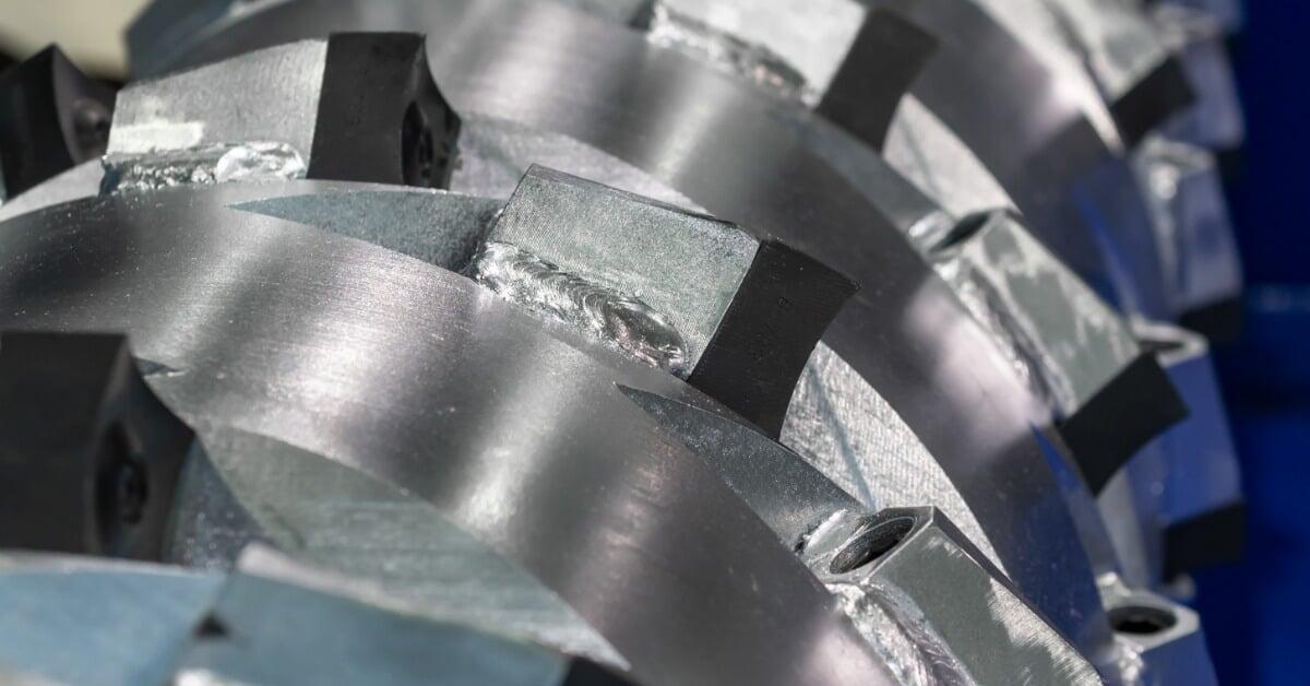 A close-up view shows rows of metal blades mounted along a cylindrical shaft inside an industrial machine.
