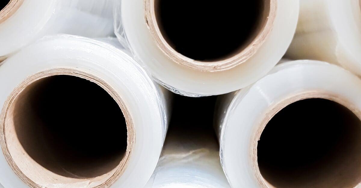 Close-up of three rows of stacked stretch wrap rolls. The cardboard centers of the rolls face the viewer.