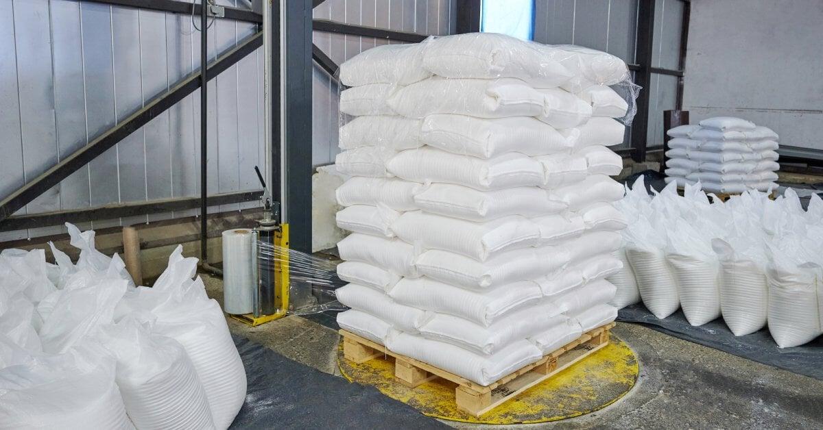 An automatic stretch wrap machine applies stretch wrap to a pallet on a turntable. The pallet includes bagged goods.