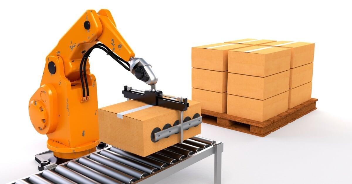 An orange robotic palletizing arm lifting a brown box from a conveyor belt and stacking it on a wooden pallet.