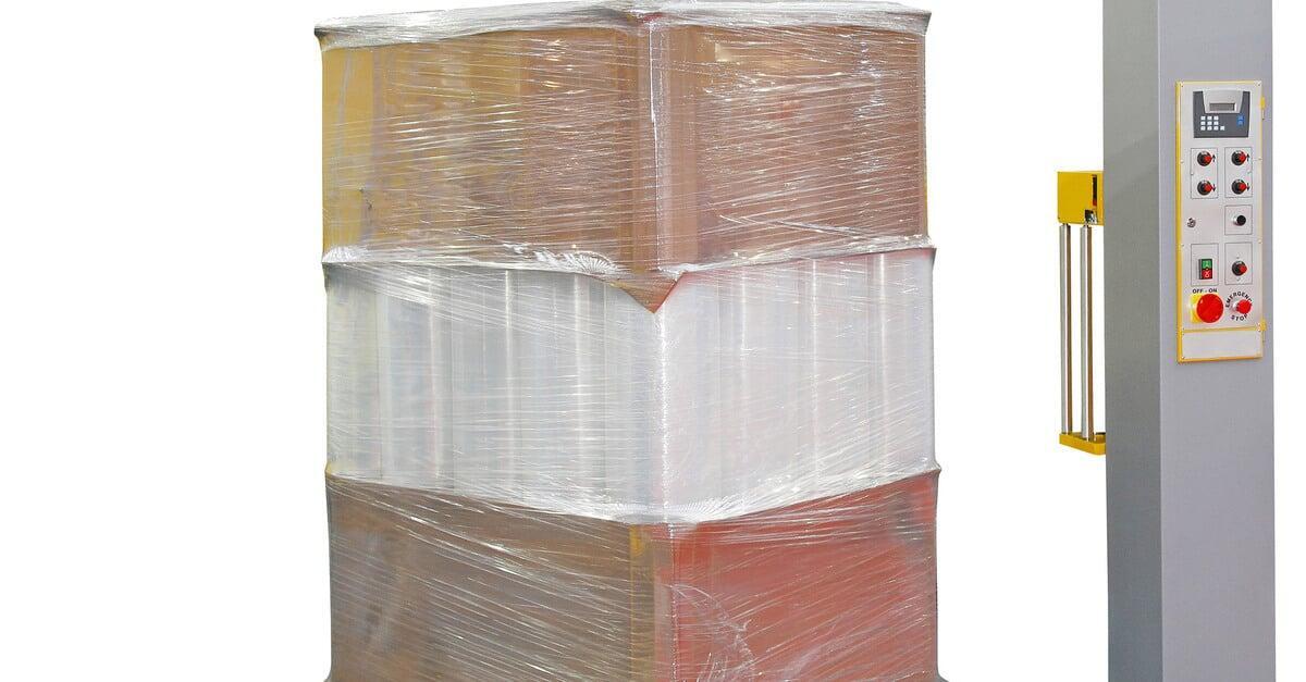 A pallet of stretch-wrapped goods standing on a stretch wrap machine's yellow turntable. The pallet has three stacked layers.