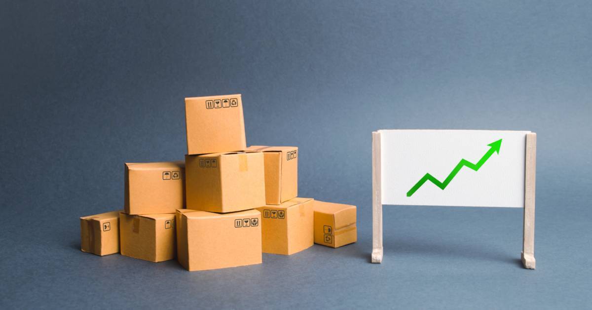 A pile of cardboard boxes next to a graph. The graph shows a green arrow in an ascending trajectory from left to right.